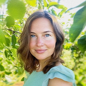 Portrét Martiny Vávrové, nutriční terapeutky, v přírodním prostředí mezi zelenými listy.